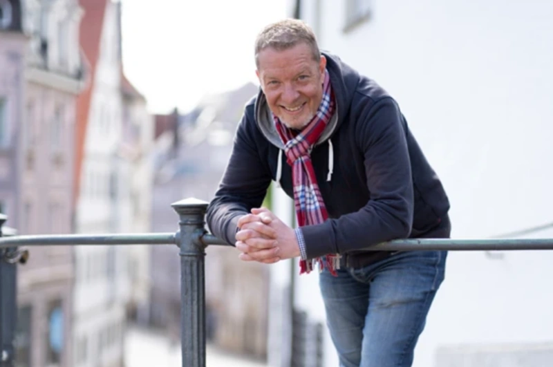 oliver foitzik lehnt an einem geländer